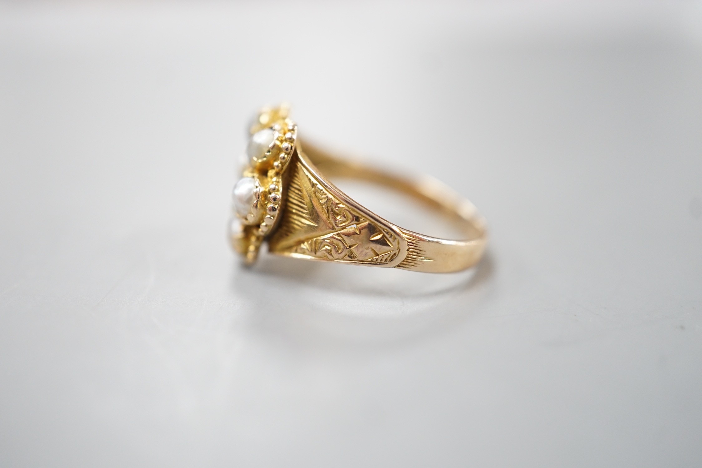 A late Victorian gold, emerald and split pearl cluster set ring, with later engraved inscription, size N, gross weight 2.9 grams.